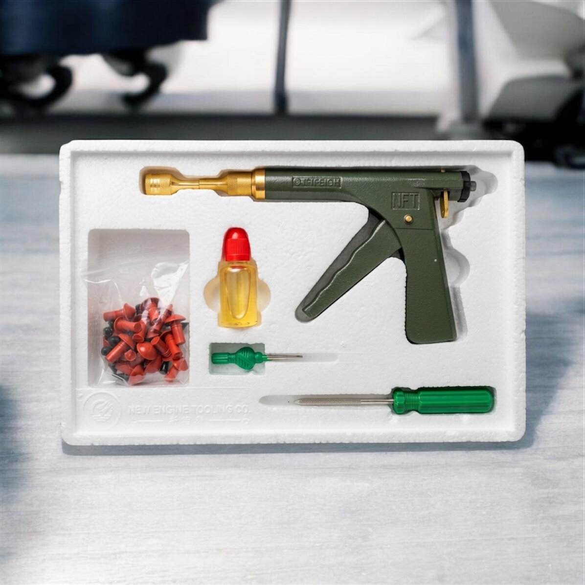 Un kit profesional de reparación rápida de neumáticos que incluye una pistola aplicadora mecánica verde y dorada, tapones cónicos de goma, lubricante y herramientas de inserción, todo organizado en una bandeja protectora a medida